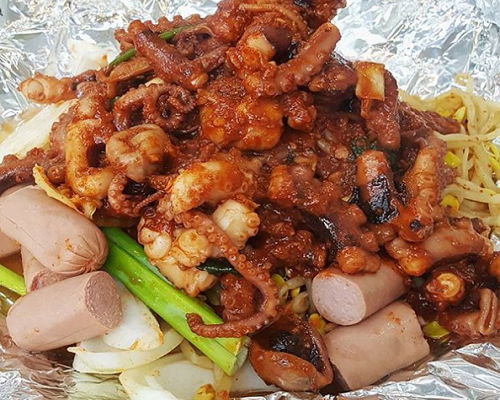 Seorin Nakji's legendary mixed spicy octopus and bacon sausage stir-fry in Seoul)