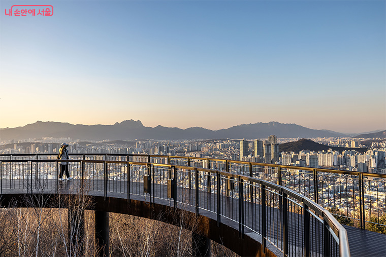 Scenic view of Seoul Trail with hikers overlooking the city skyline.